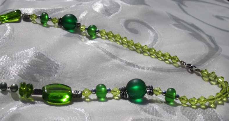 Necklace back closeup: peridot glass bicone beads, emerald green round glass beads, silver tone butterfly beads